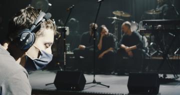 A photo of a band with a young man wearing a COVID mask